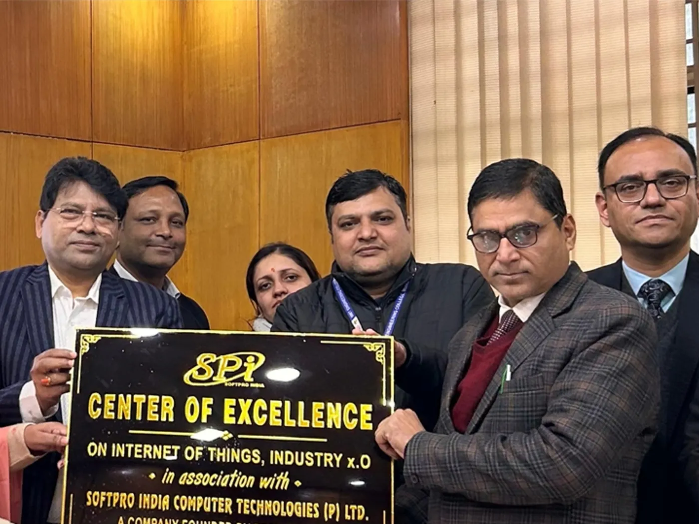 Softpro India and IIMT University staff holding the Center of Excellence name plate