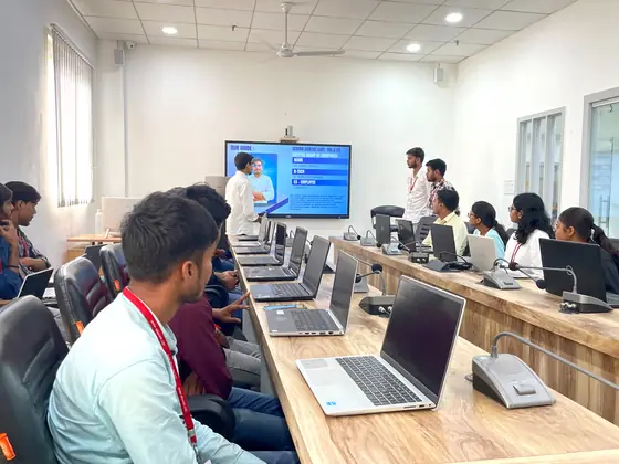 Students at the bench watching a demonstration on the screen at the front of the room