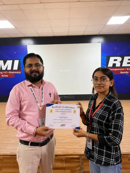A Softpro trainer handing a star performer certificate to a student in front of the event backdrop