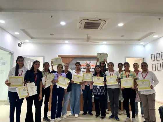 A batch of students holding their certificates up together at the training centre