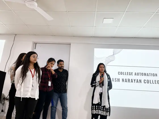 A student presenting a college automation project, the title slide behind her