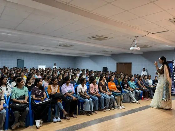 Wide view of a full auditorium during a Softpro session, students seated shoulder to shoulder