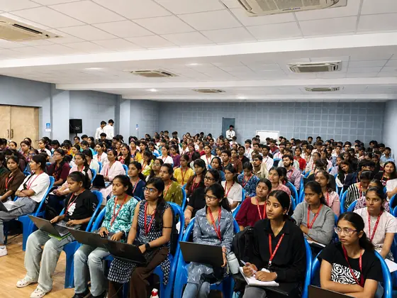 Front rows of students with laptops open on their laps during a training session