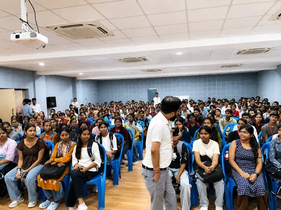 A trainer standing among the seated students, mid-explanation