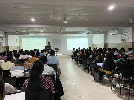 A hall seen from the back during a session, two screens lit at the front