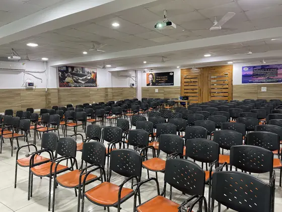 Rows of empty orange and black chairs in a hall set up before a session