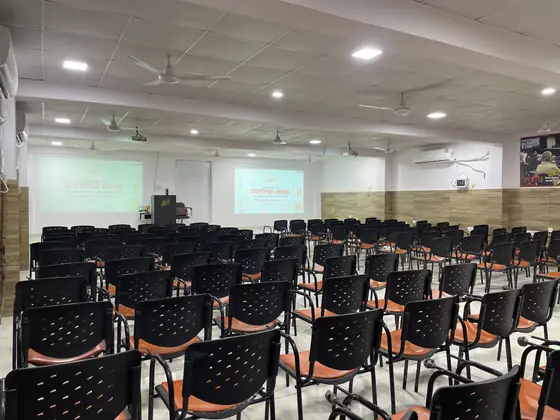 An empty auditorium with the Softpro India title slide already on screen